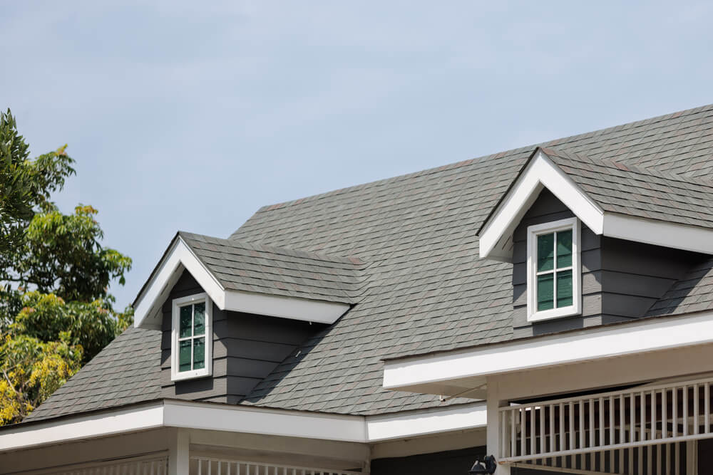 Roof shingles with garret house on top of the house. dark asphal