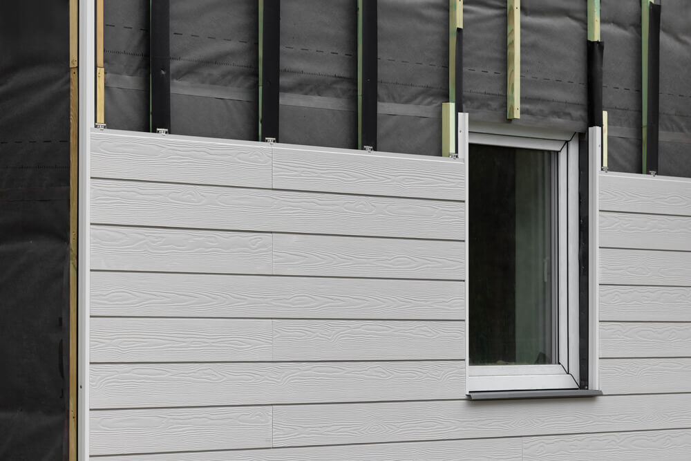 wood texture composite cladding installation on house facade. WPC exterior wall panels